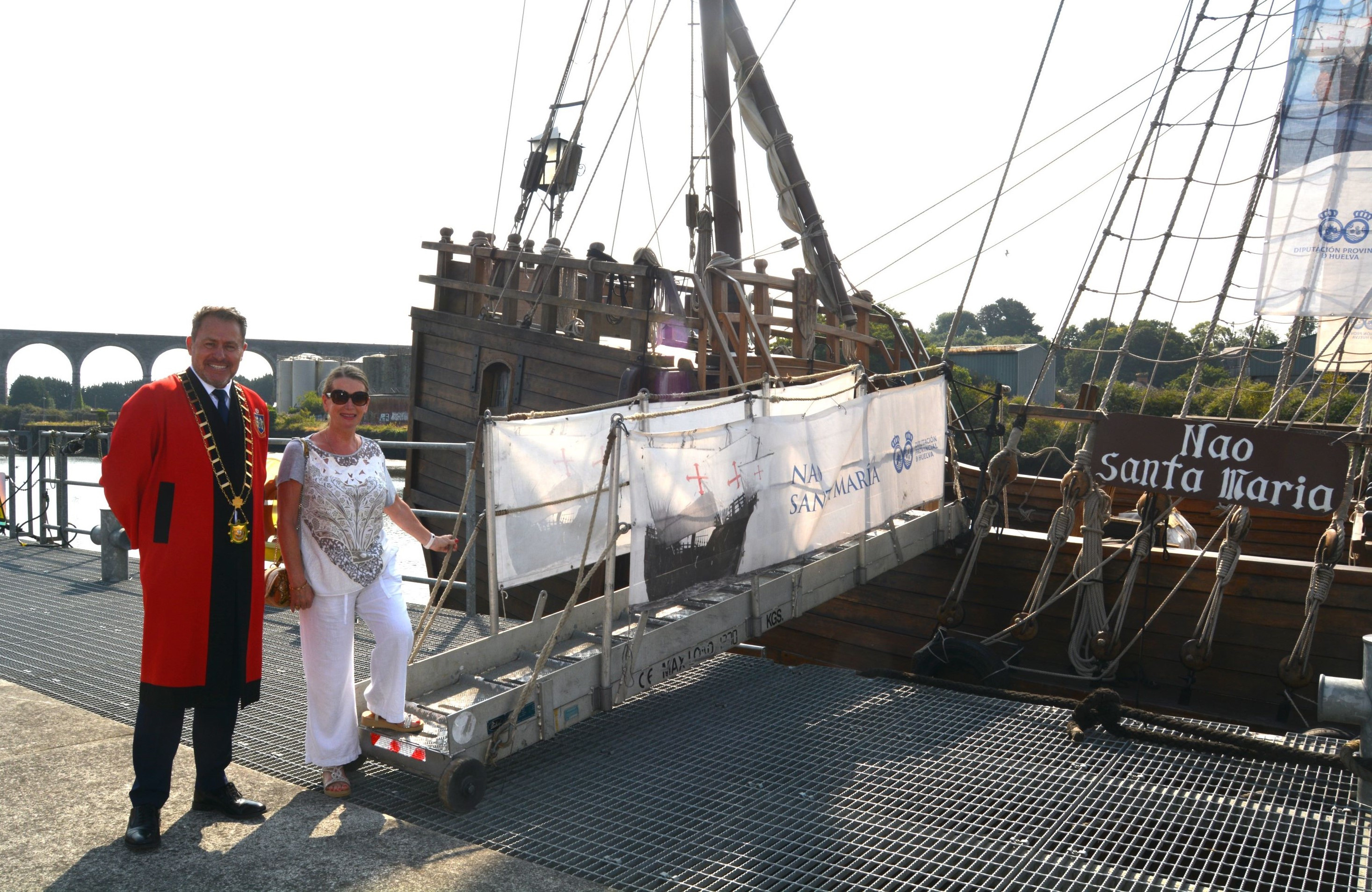 image of 2 people standing alongside ship